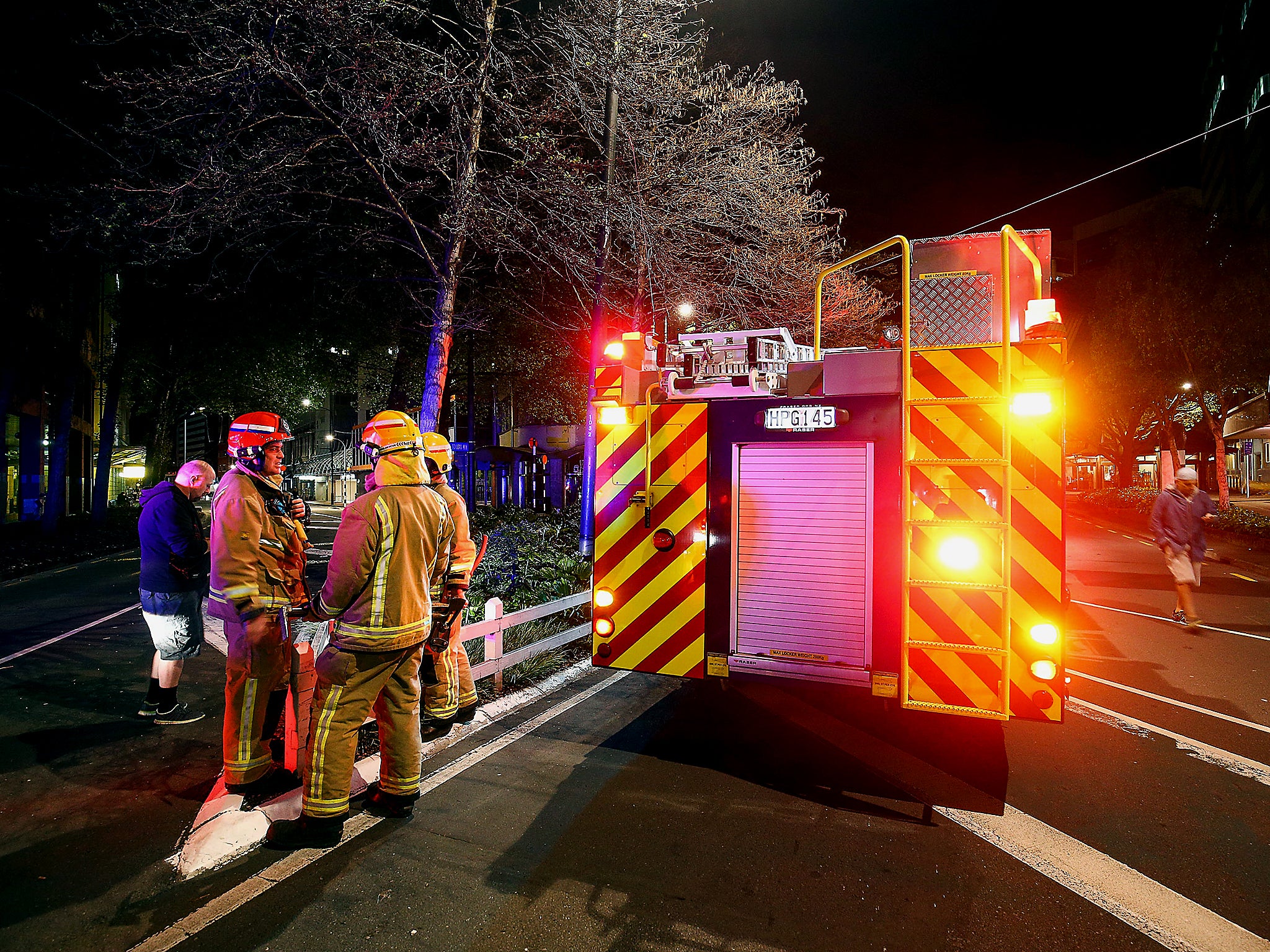 Firemen gather at the corner of Wakefield and Victoria Streets after an earthquake in Wellington, New Zealand