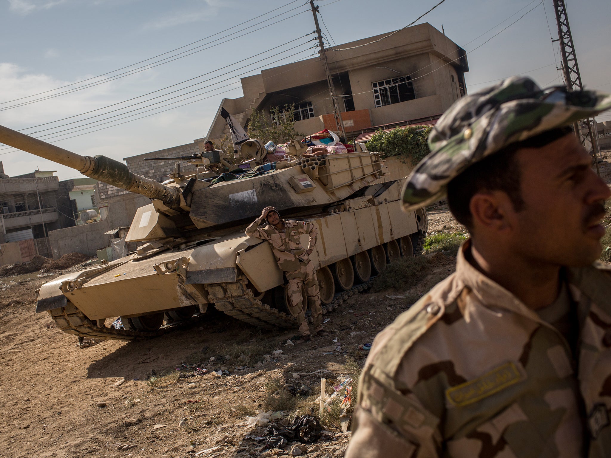 Soldiers from the Iraqi Army take a break in a street just behind the frontline in the Intisar neighbourhood of Mosul