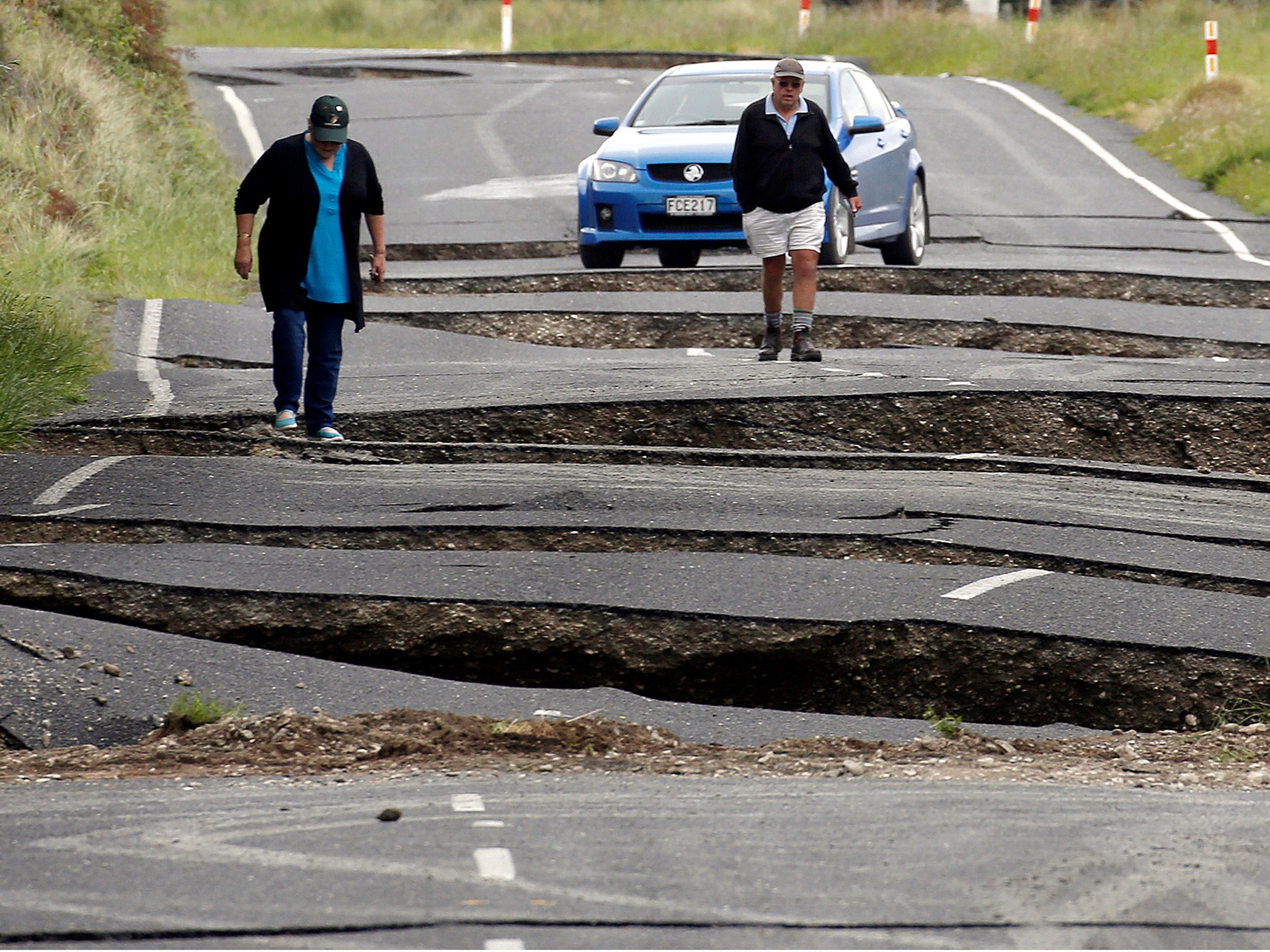 Local residents Chris and Viv Young look at damage caused by an earthquake, along State Highway One near the town of Ward, south of Blenheim on New Zealand's South Island