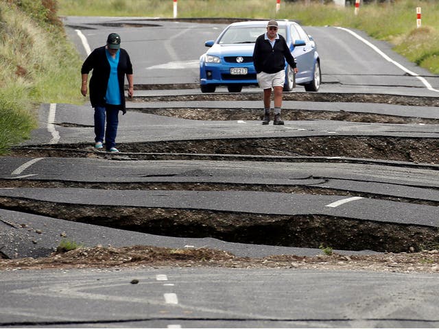Local residents Chris and Viv Young look at damage caused by an earthquake, along State Highway One near the town of Ward, south of Blenheim on New Zealand's South Island