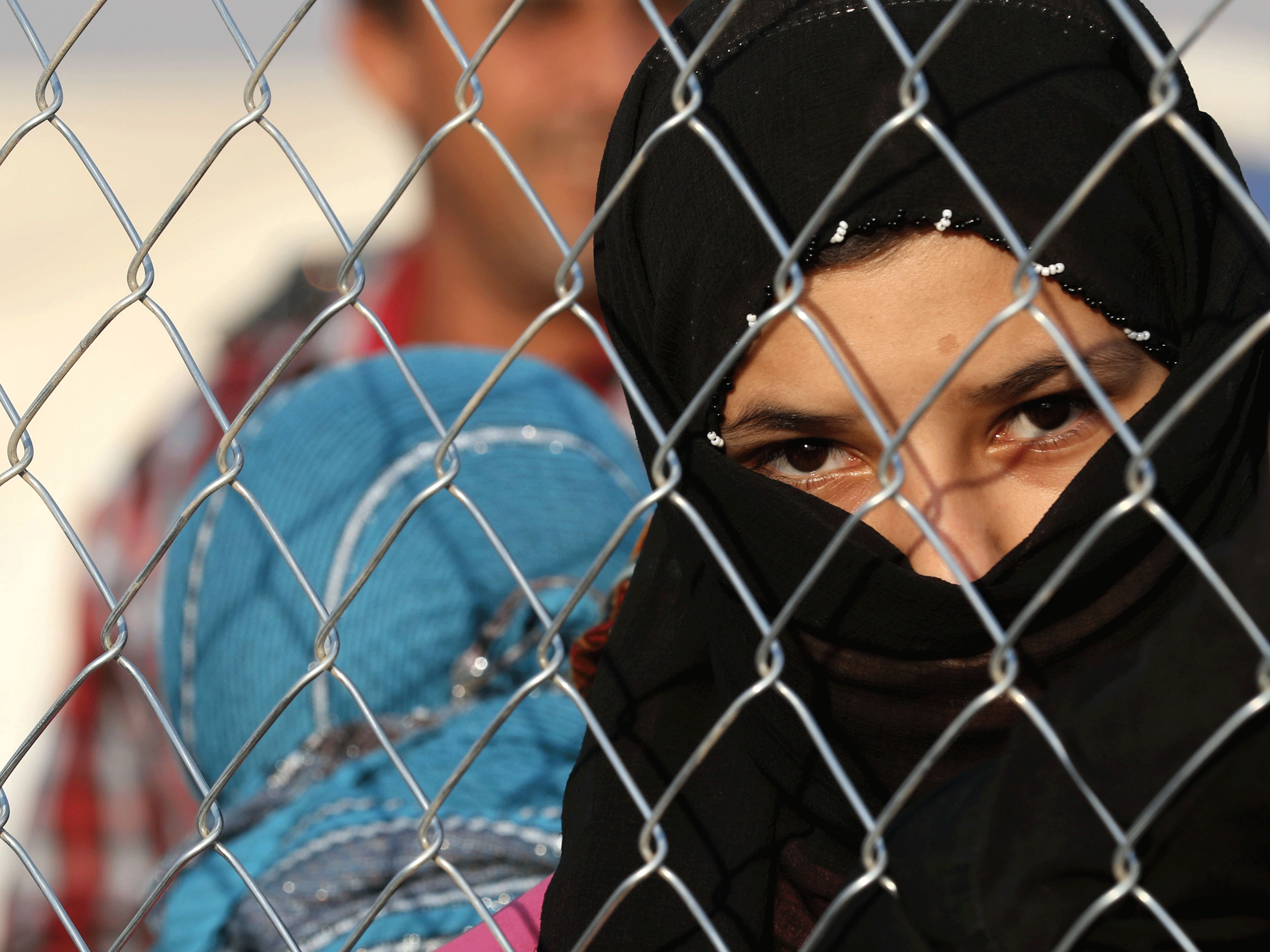 Thousands, including this Iraqi girl at the fencing of the Hasan Sham camp, have fled under-siege Mosul in Iraq