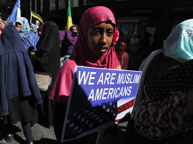 A girl wearing a Muslim headscarf holds a sign during the annual Muslim Day Parade in the Manhattan borough of New York City