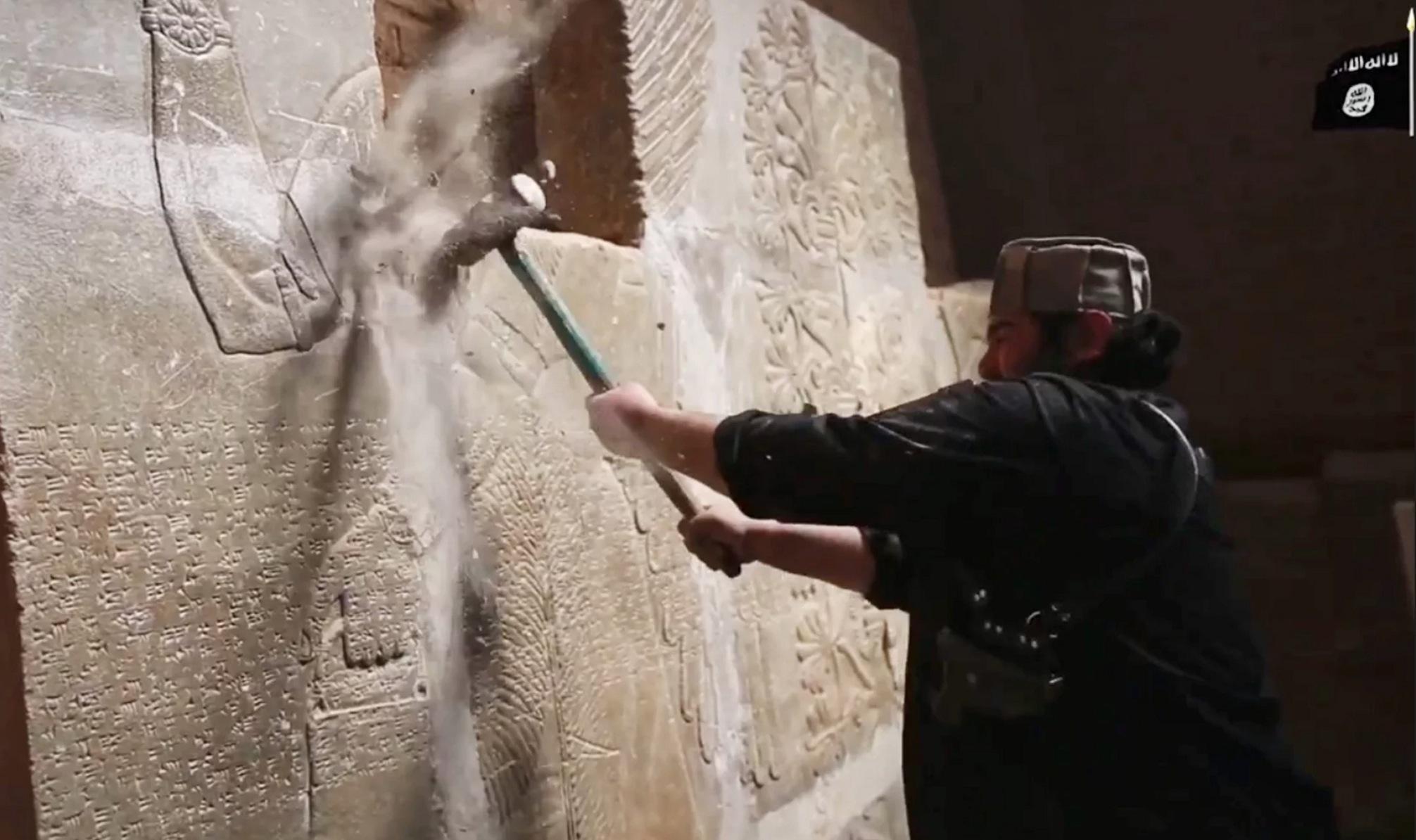 An Isis militant sets about destroying an ancient Assyrian frieze in Nimrud in 2015