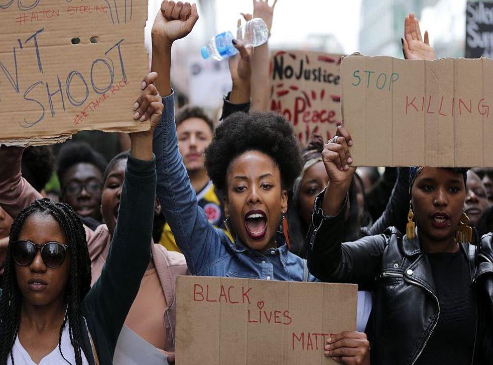 Demonstrators from the Black Lives Matter movement march through central London on July 10, 2016, during a demonstration against the killing of black men by police in the US.