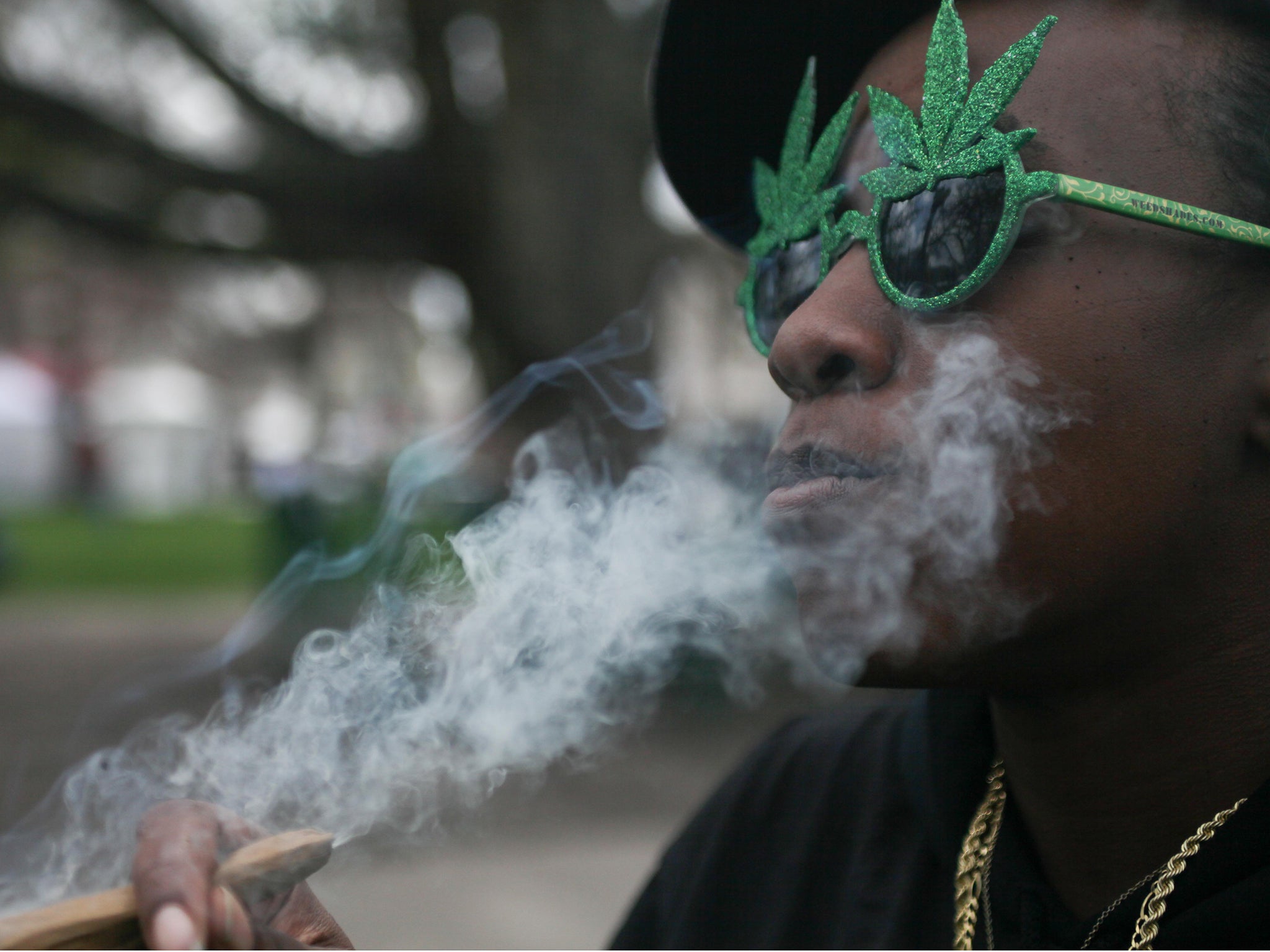 A woman smokes Marijuana at the Denver 420 Rally at Civic Center Park