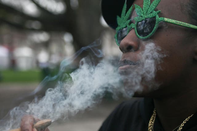 A woman smokes Marijuana at the Denver 420 Rally at Civic Center Park