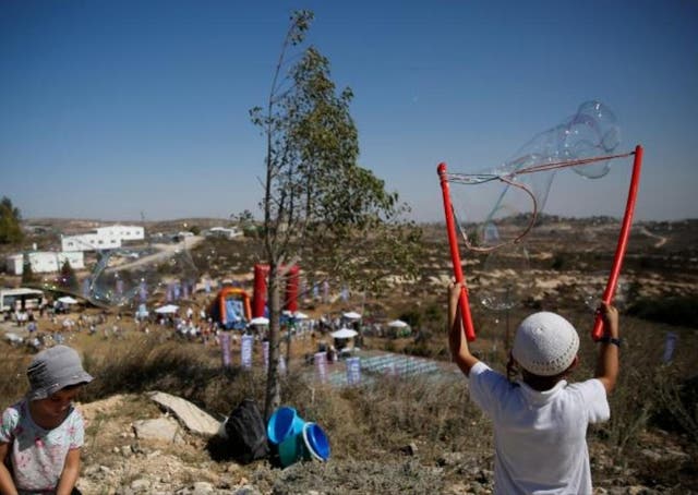 Children play during an event organised to show support for the Jewish settler outpost of Amona in the West Bank which the Israeli High Court ruled must be cleared (Reuters)