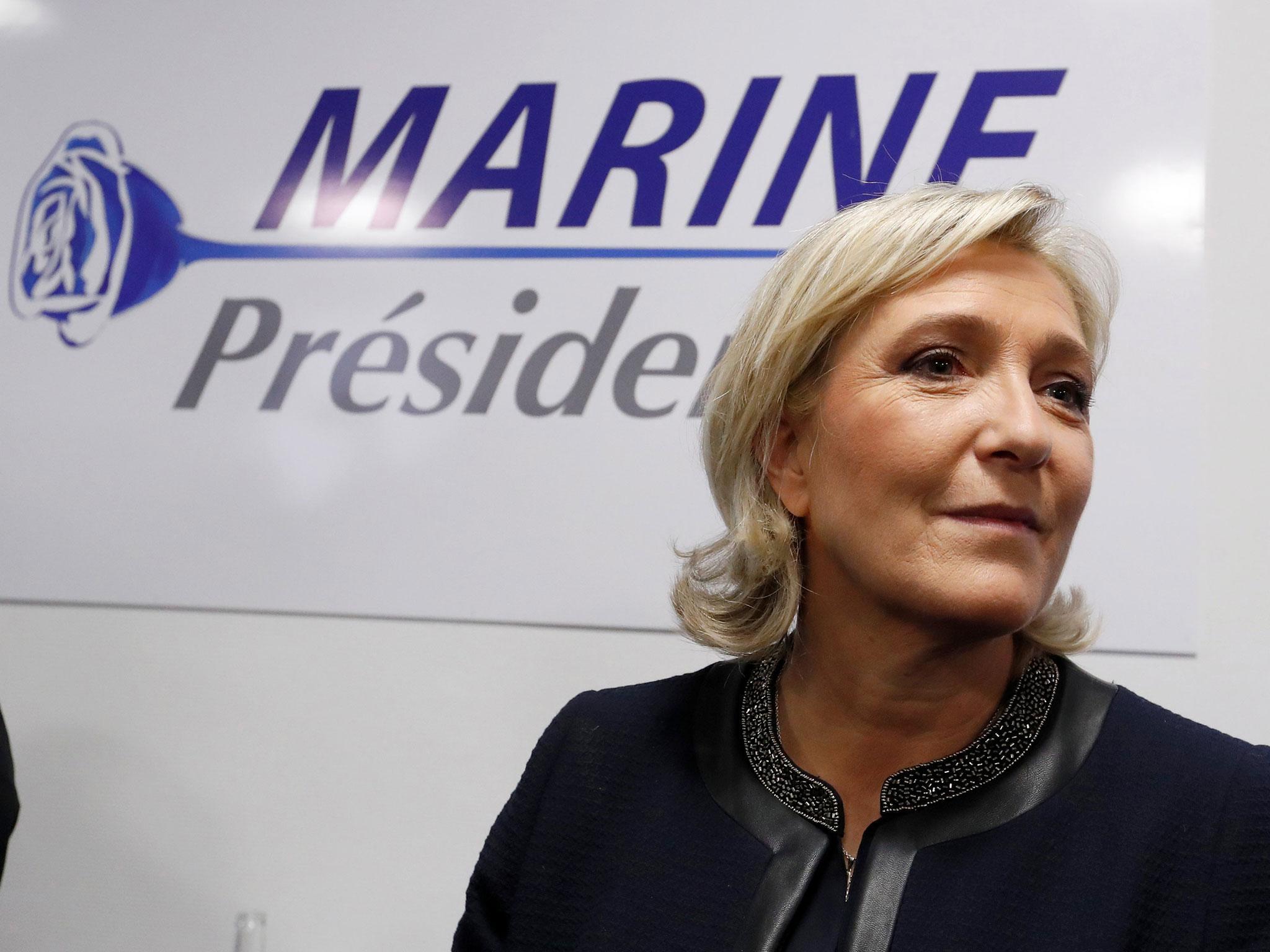 France's far-right National Front leader Marine Le Pen poses in front of a poster for her 2017 French presidential election campaign as she inaugurates her party campaign headquarters in Paris in November 2016