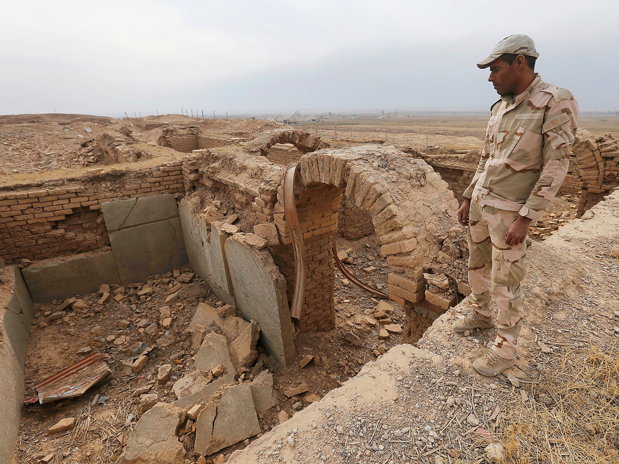 An Iraqi soldier looks to the damaged ancient site of Nimrud, which was destroyed by Islamic State militant. The government said the IS militants, who captured the site in June 2014, destroyed it the following year, using heavy military vehicles