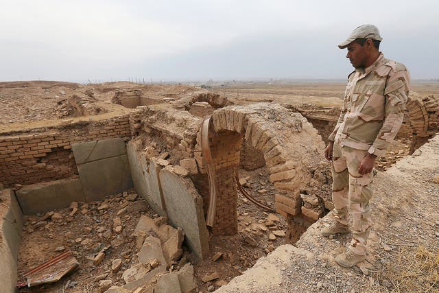 An Iraqi soldier looks to the damaged ancient site of Nimrud, which was destroyed by Islamic State militant. The government said the IS militants, who captured the site in June 2014, destroyed it the following year, using heavy military vehicles