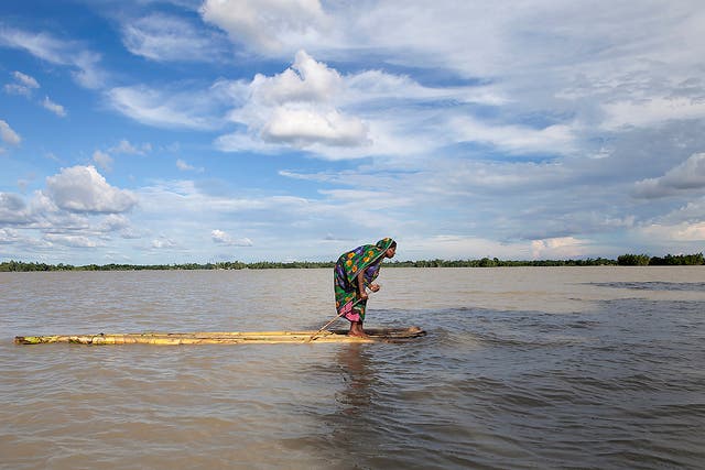 A woman searches for dry land after a flood in Bangladesh, a country already affected by cyclones, floods and drought
