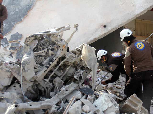 Rescuers inspect a destroyed building in the Syrian village of Kfar Jales, on the outskirts of Idlib, following air strikes by Syrian and Russian warplanes