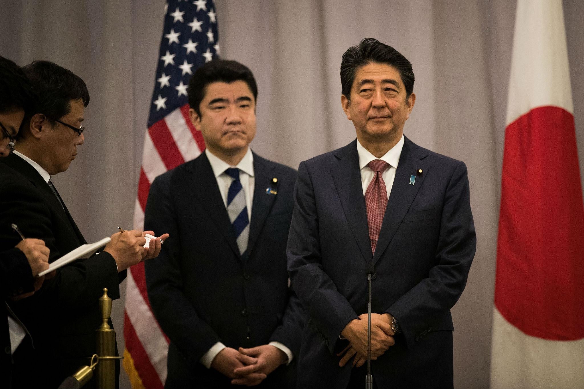 Japanese Prime Minister Shinzo Abe (right) speaks to members of the press after meeting Donald Trump last night