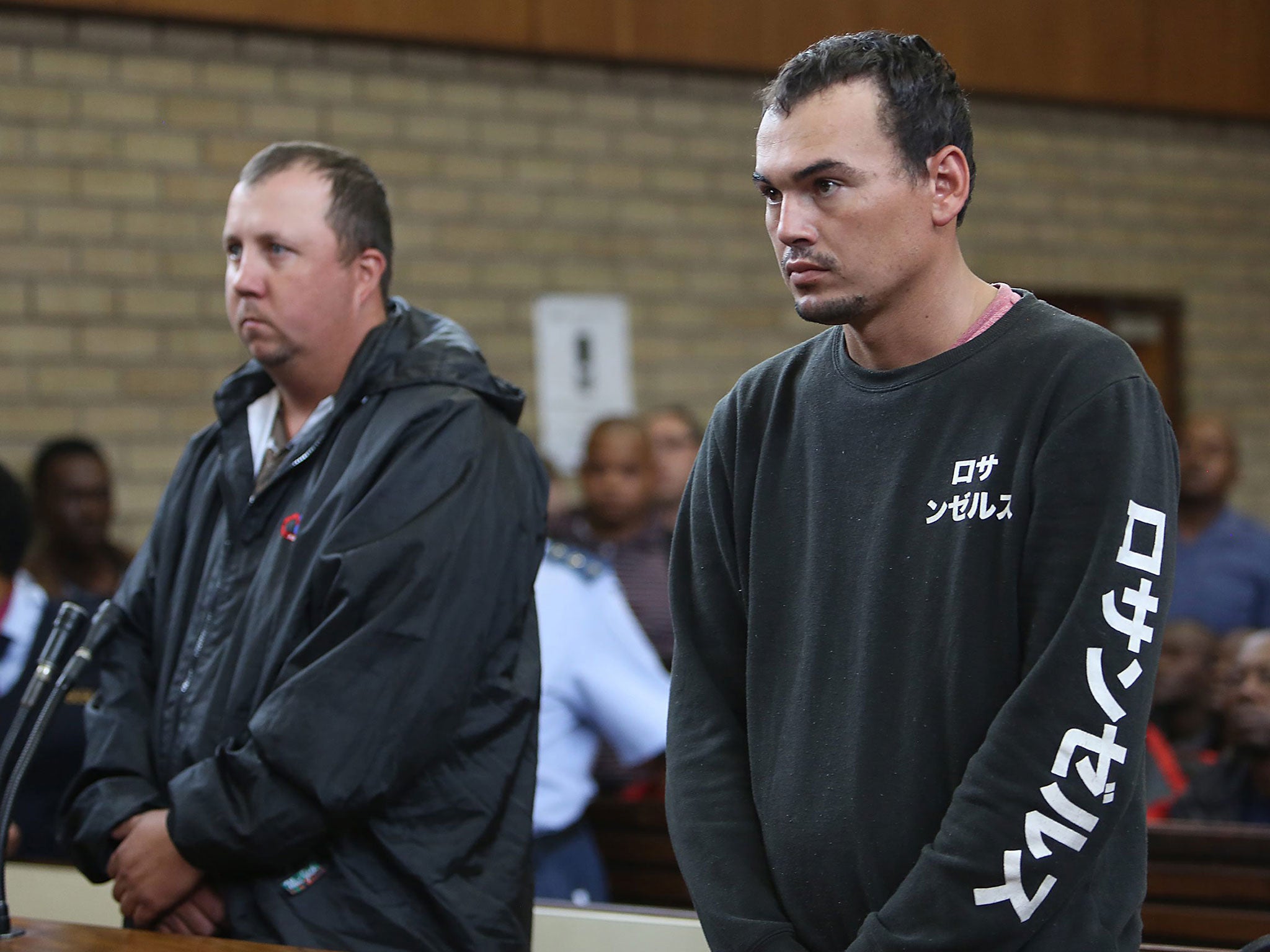 Theo Jackson (L) and Willem Oosthuizen (R), on trial for allegedly assaulting a black man and forcing him into a coffin, on trial in Middleburg, South Africa, 16 November
