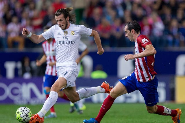 Bale dribbles past Godin in last season's meeting at the Vicente Calderon