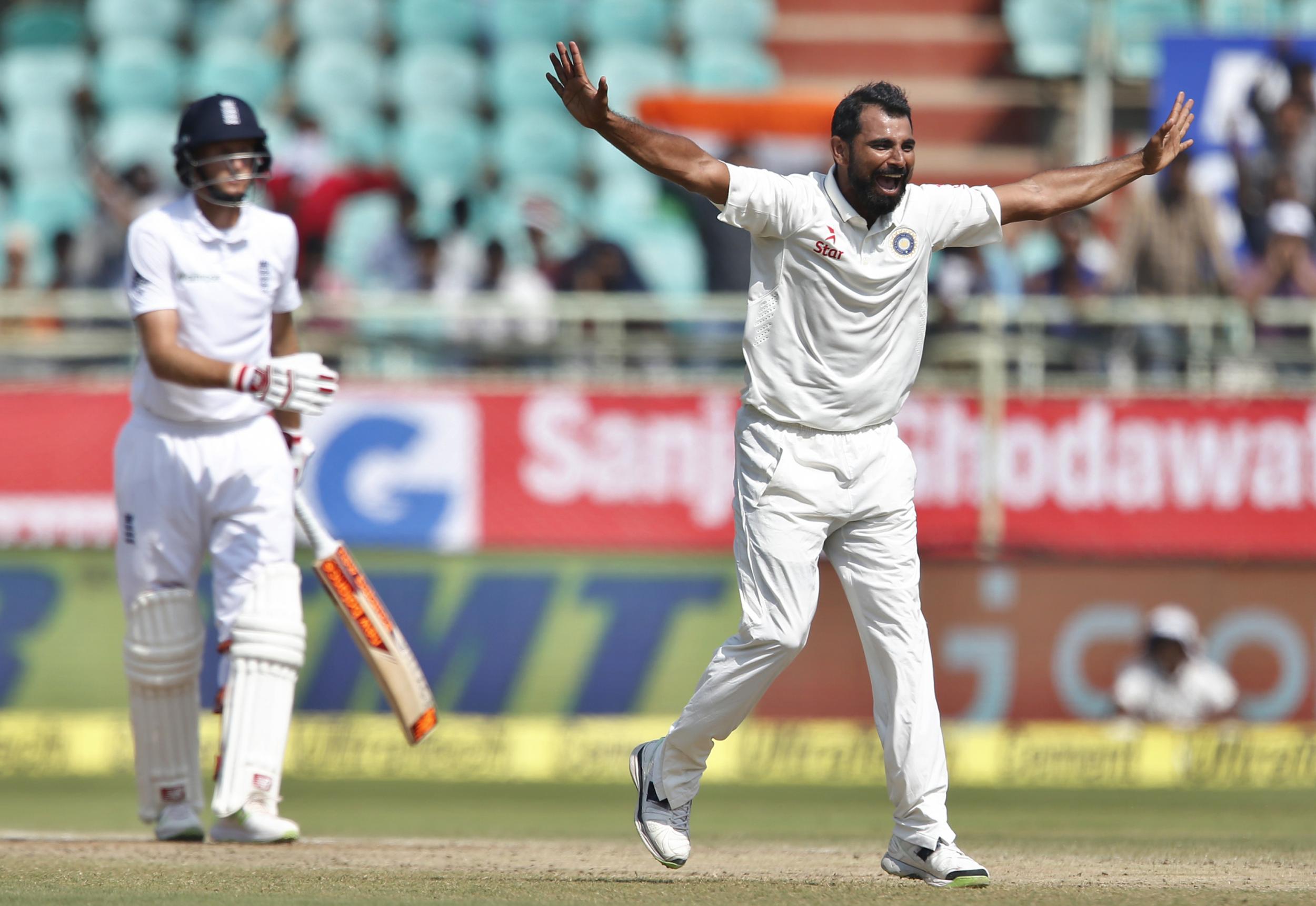 India's Mohammed Shami, right, celebrates the dismissal of England's Joe Root, left.