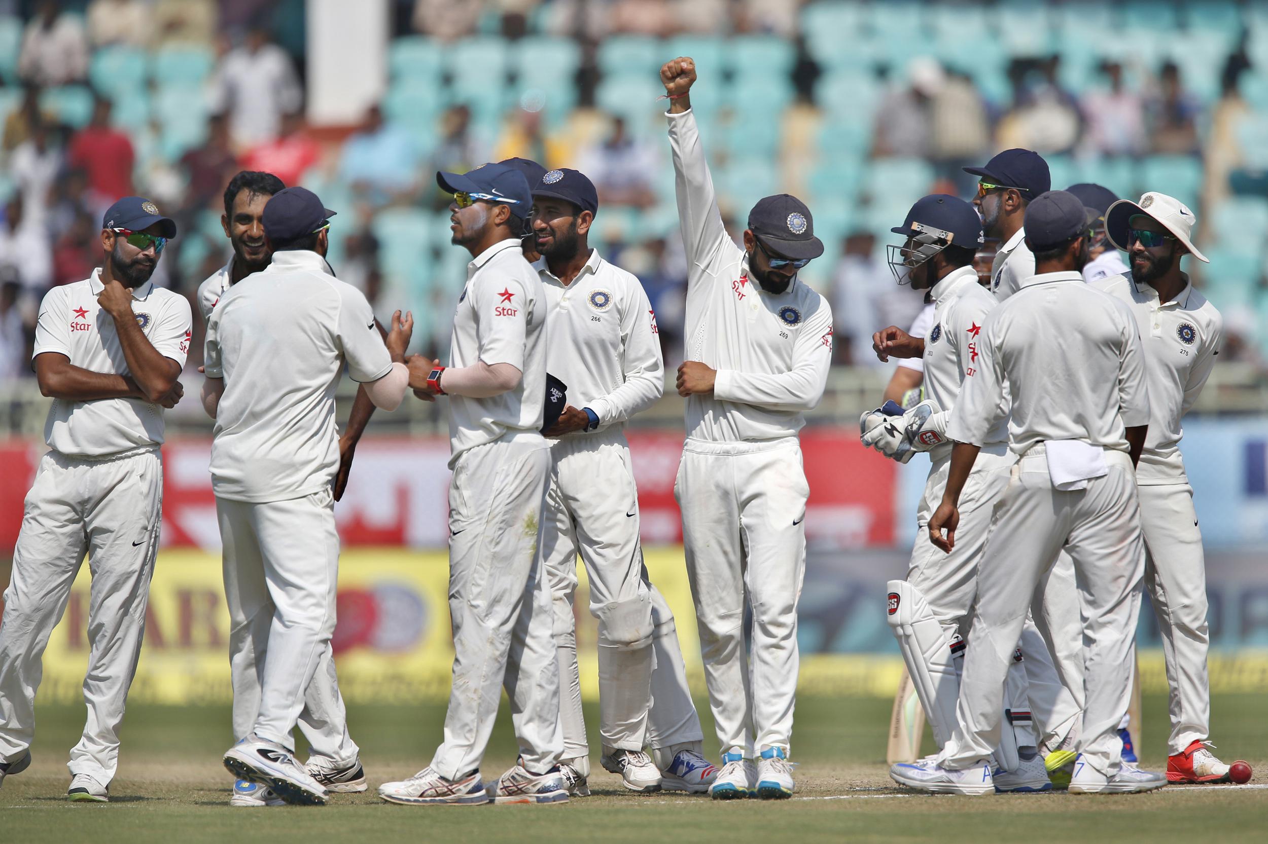 India's captain Virat Kohli, center, raises his arm to celebrate with teammates their win over England in the second cricket test match in Visakhapatnam, India.