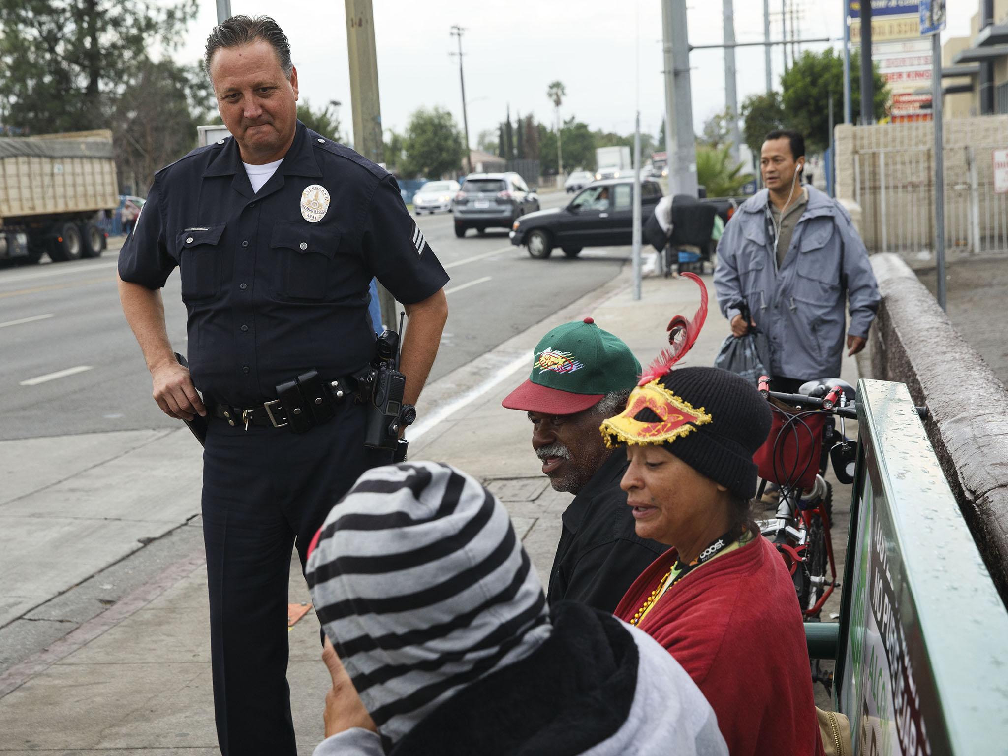 Sgt Coleman speaks with local people at a bus stop on his beat (Patrick T Fallon)