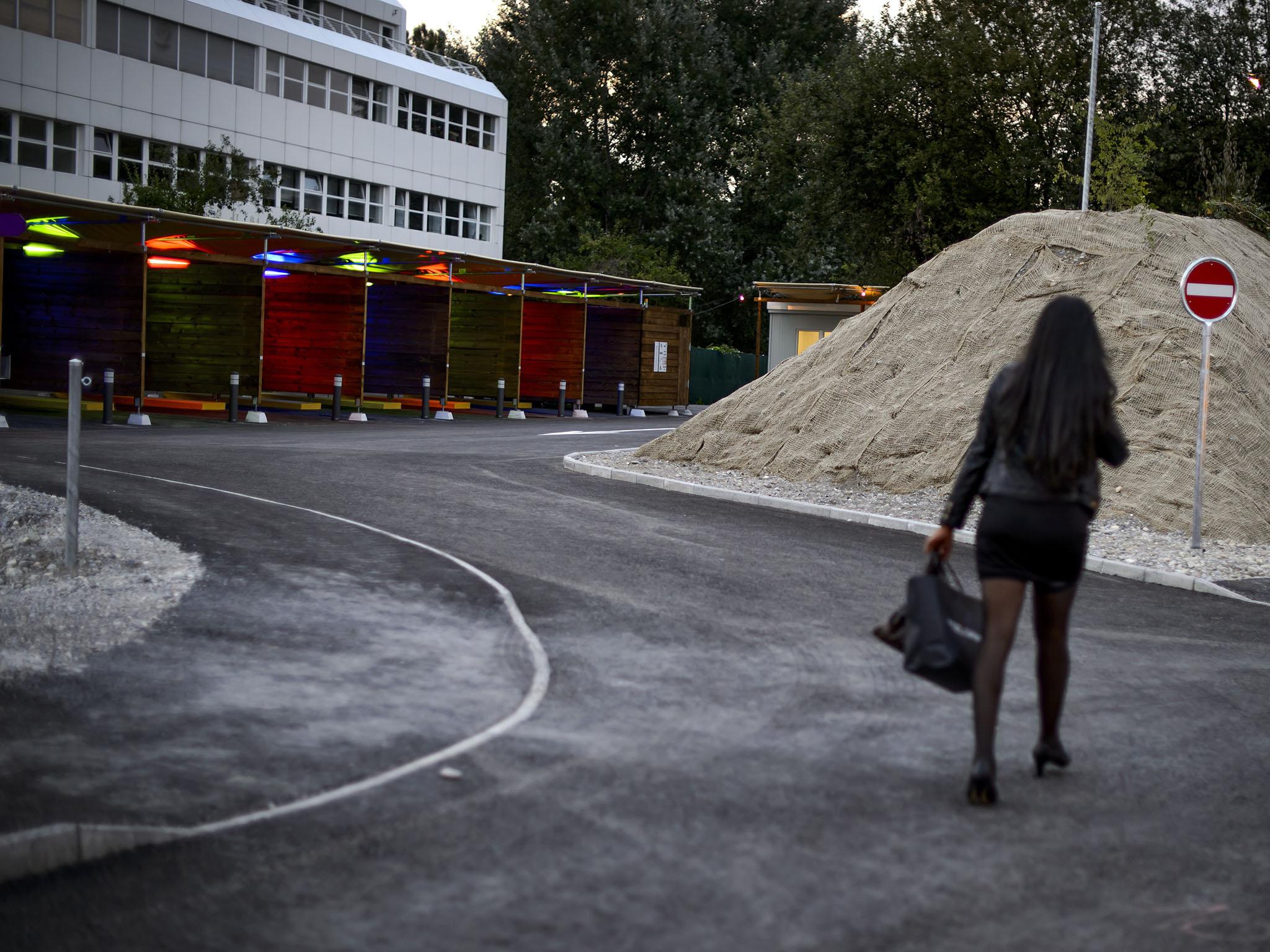 A prostitute walks past so-called ‘sex boxes’ at the opening day of Switzerland's first sex drive-in on 26 August 2013 in Zurich