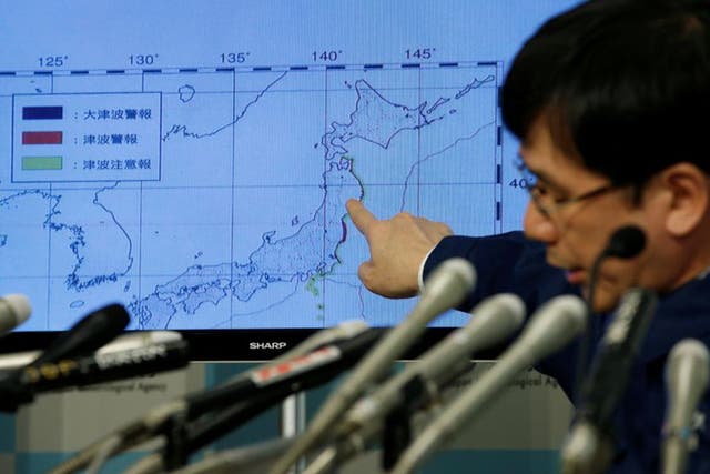 Japan Meteorological Agency's earthquake and volcano observations division director Koji Nakamura points at a map showing earthquake information during a news conference in Tokyo yesterday