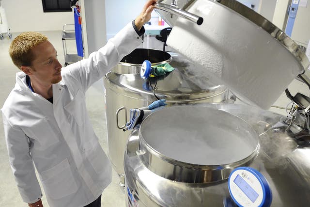 A technician opens a vat of liquid nitrogen, used in cryogenic freezing