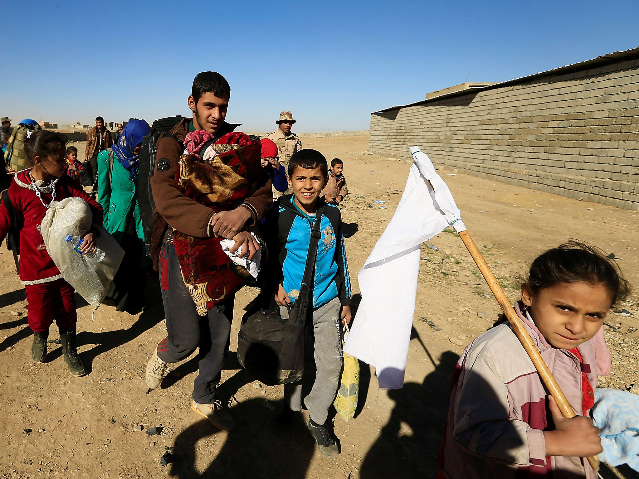 Displaced people fleeing from Islamic State militants in Tahrir neighborhood, walk in Mosul, Iraq