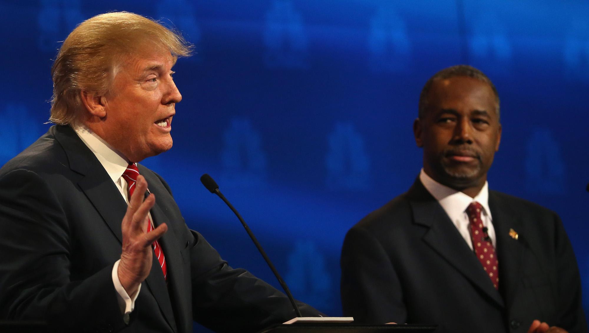 Presidential candidates Donald Trump speaks while Ben Carson looks on during the CNBC Republican Presidential Debate at University of Colorados Coors Events Center October 28, 2015 in Boulder, Colorado. Fourteen Republican presidential candidates are participating in the third set of Republican presidential debates.