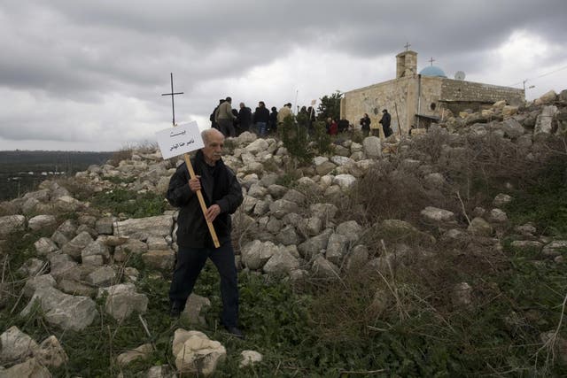 A Palestinian Christian man walks in the rubble of Iqrit village to place the name of the owner on the site of a destroyed house on the site. Residents were ordered to leave in October 1948, during the first Israeli-Arab war