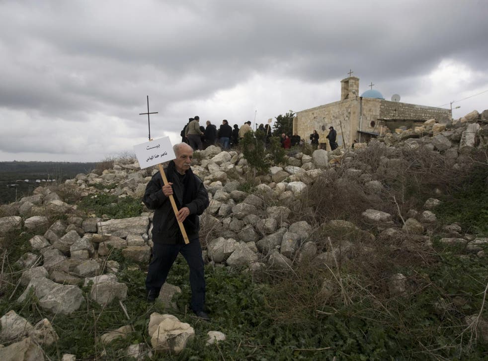 A Palestinian Christian man walks in the rubble of Iqrit village to place the name of the owner on the site of a destroyed house on the site. Residents were ordered to leave in October 1948, during the first Israeli-Arab war