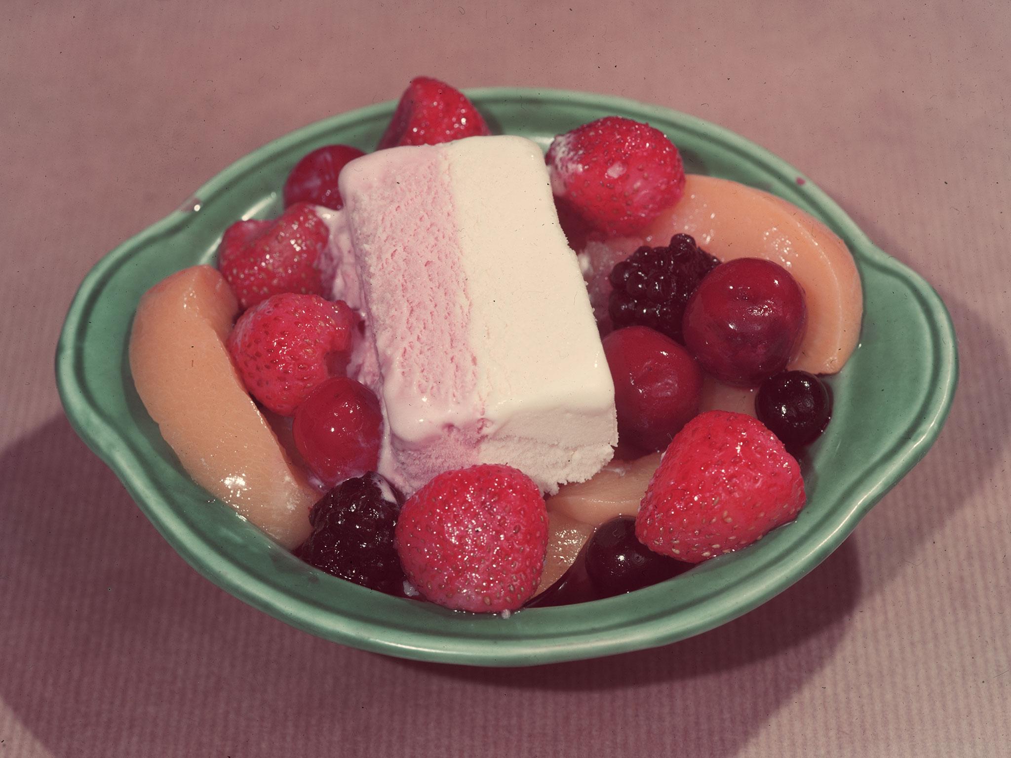 Tinned strawberries, cherries, blackberries, blackcurrants and sliced peaches topped with Neapolitan icecream circa 1950