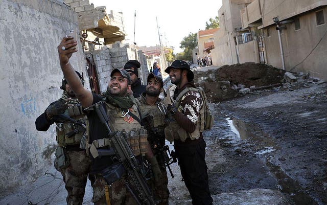 A soldier from the Iraqi Special Forces takes a selfie after the Aden district of Mosul was retaken from Isis on November 22nd, 2016 