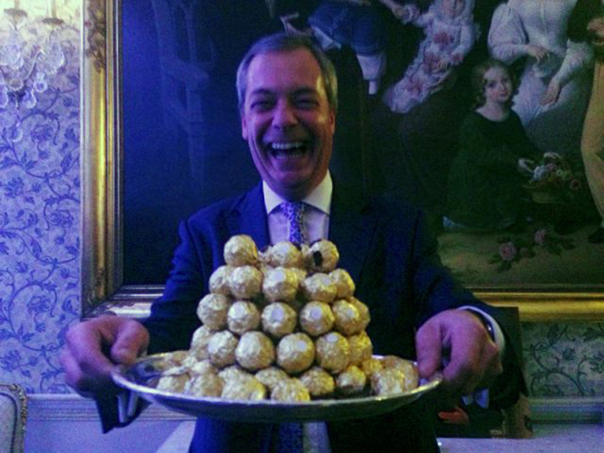 Nigel Farage holds a platter of Ferrro Rocher chocolates during a party in London