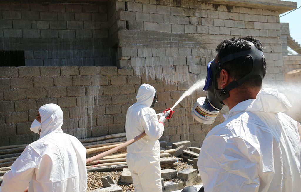 Members of the civil defence service spray and clean areas in the town of Taza in northern Iraq on March 13, 2016, after a suspected chemical attack by Isis