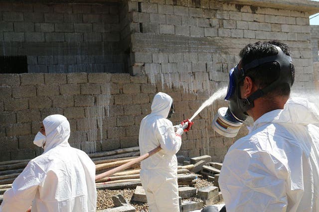 Members of the civil defence service spray and clean areas in the town of Taza in northern Iraq on March 13, 2016, after a suspected chemical attack by Isis