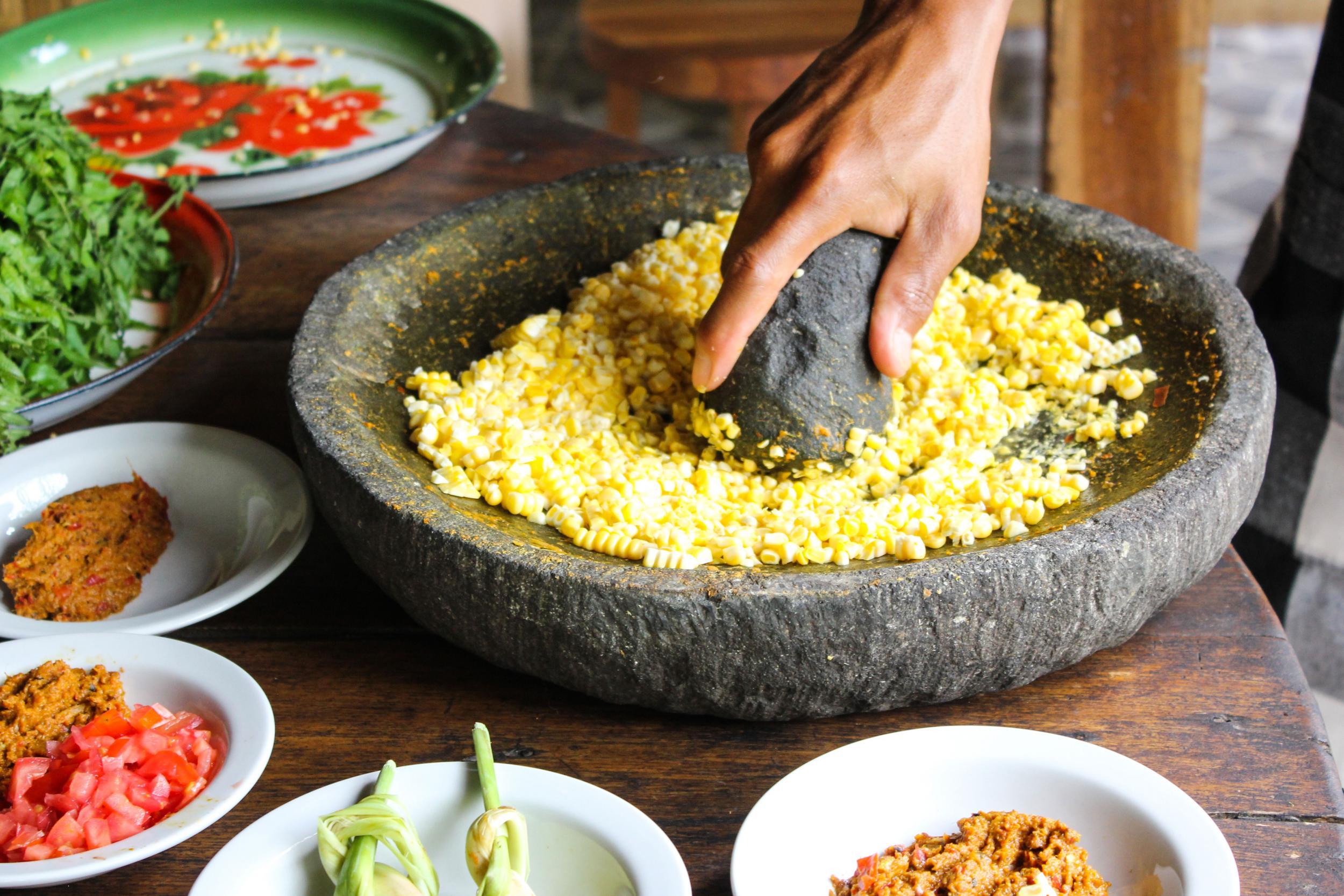 Corn for the fritters is hand-ground with a large pestle and mortar