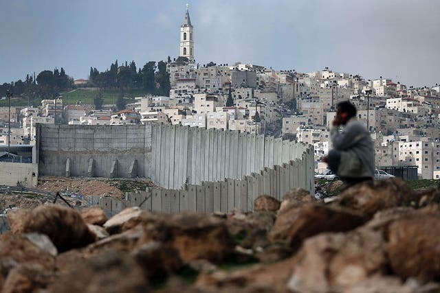 A Palestinian man sits near Israel's controversial separation barrier dividing the Palestinian neighbourhood of Al-Tur in the Israeli annexed East Jerusalem on February 11, 2016