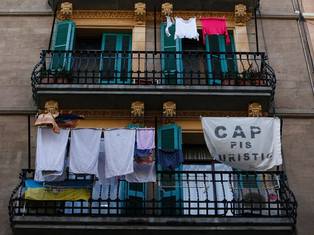 A banner reading 'No tourist flats' hangs from a balcony to protest against holiday rental apartments for tourists in Barcelona's neighborhood of Barceloneta