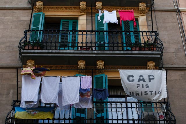 A banner reading 'No tourist flats' hangs from a balcony to protest against holiday rental apartments for tourists in Barcelona's neighborhood of Barceloneta
