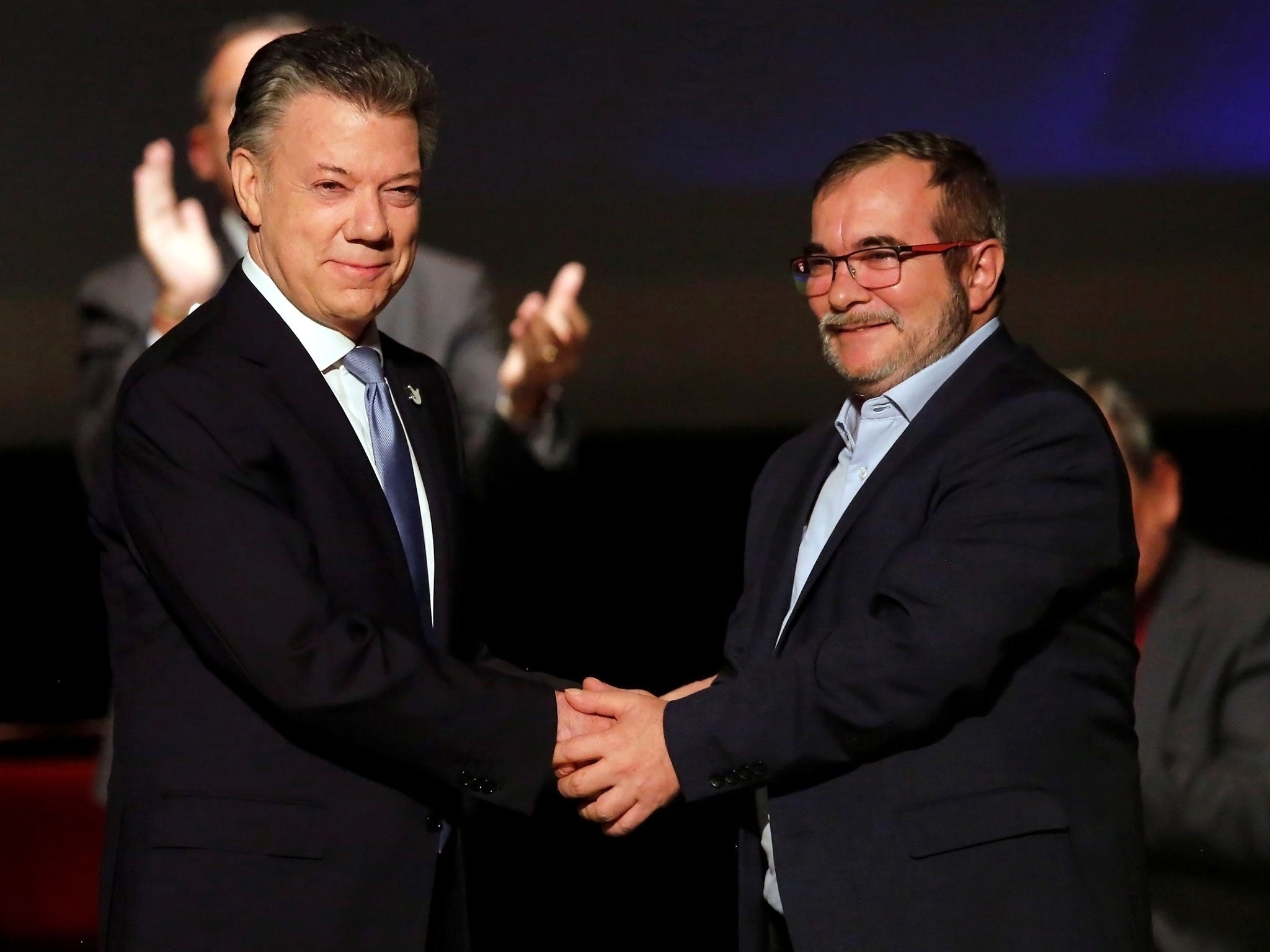 Colombia's President Juan Manuel Santos and Farc rebel leader Rodrigo Londono shake hands after signing the peace accord