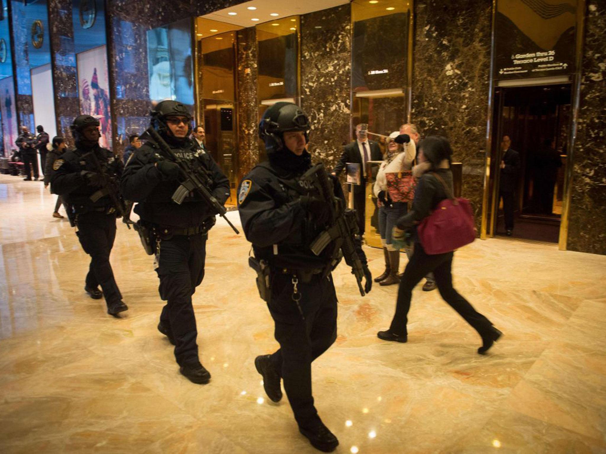 Heavily armed police walk through the lobby of Trump Tower