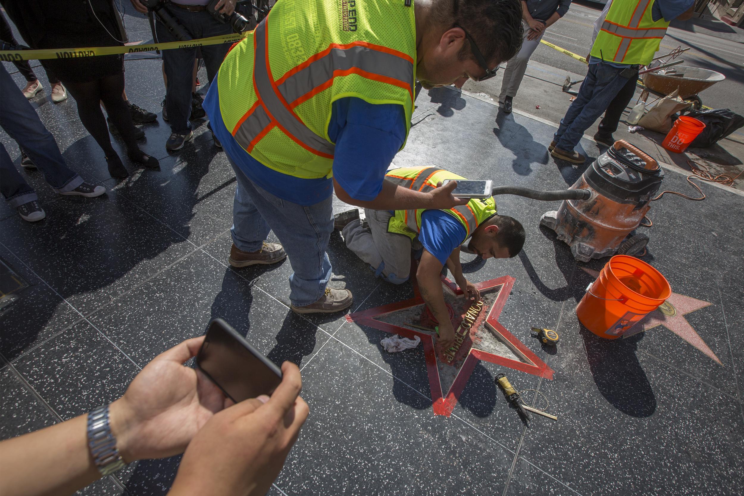 Workers repair the plaque after it was vandalised last month