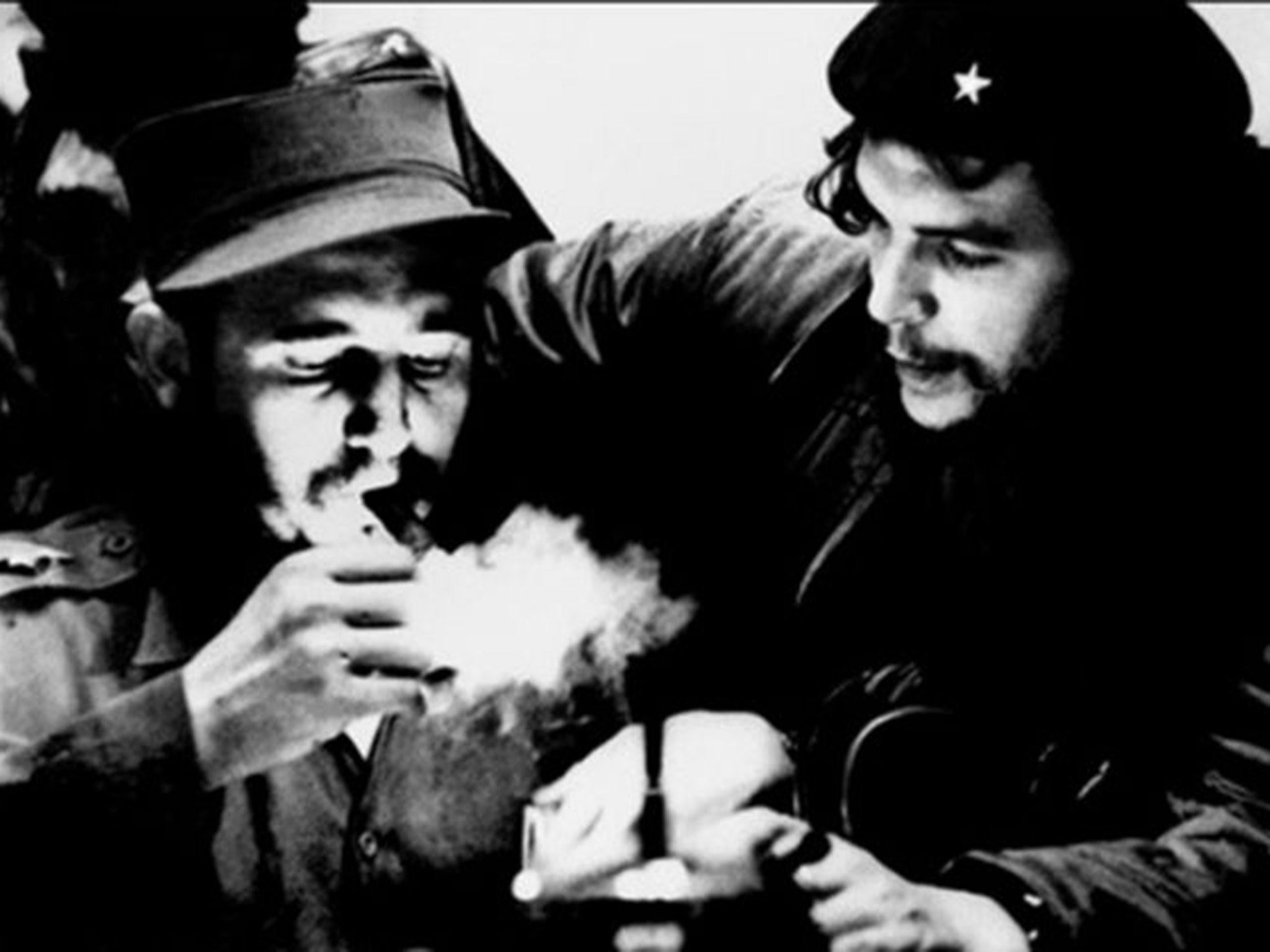This file photo taken in the 1960s shows then-Cuban prime minister Fidel Castro lighting a cigar while listening to Che Guevara