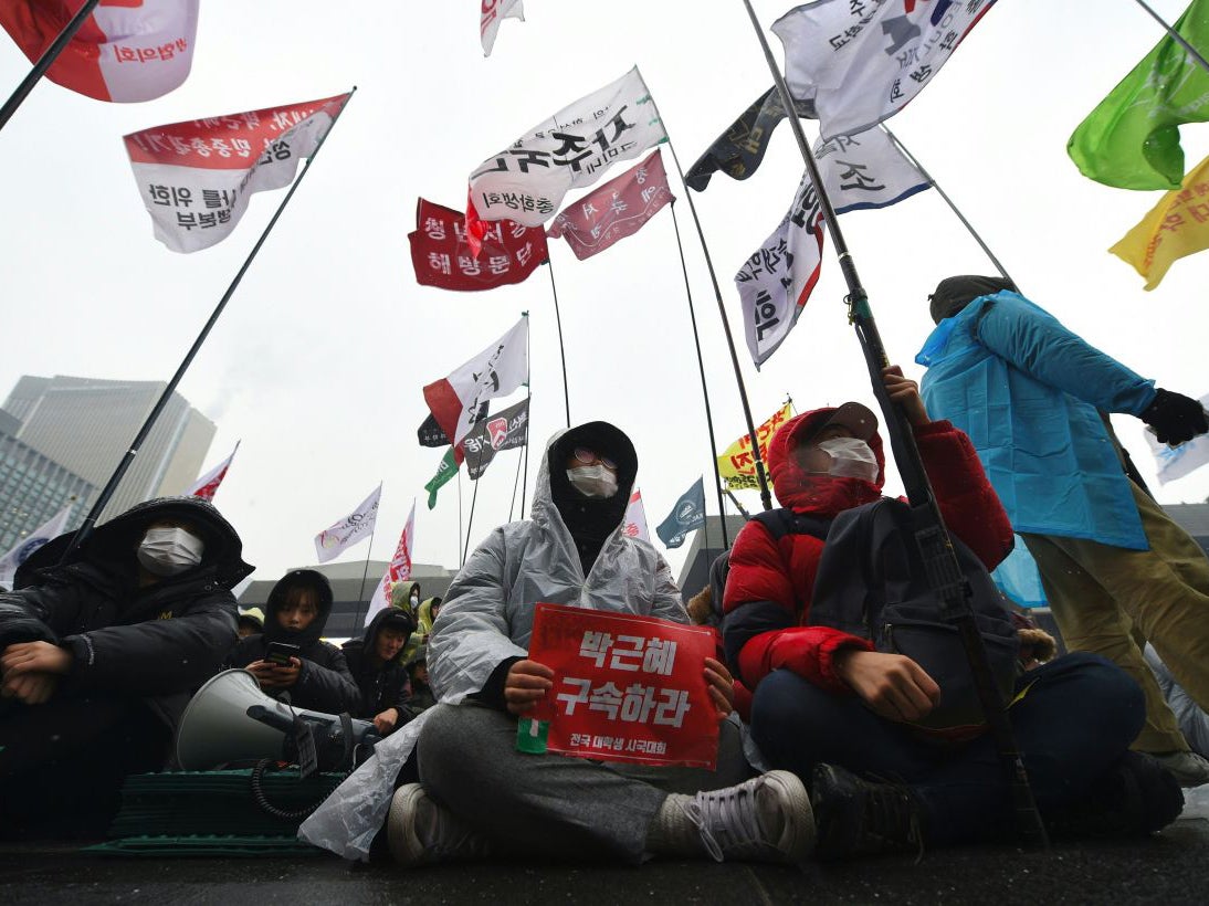 Protesters sit on the street during an anti-government rally demanding the resignation of South Korea's President Park Geun-Hye