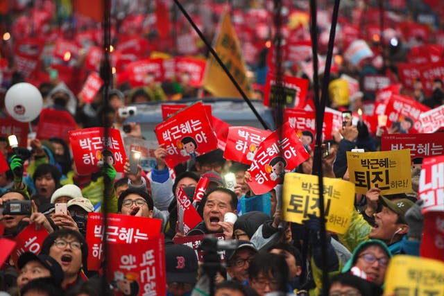 Protesters shout slogans as they march toward the presidential Blue House to press their demand for the resignation of South Korea's President Park Geun-Hye in central Seoul
