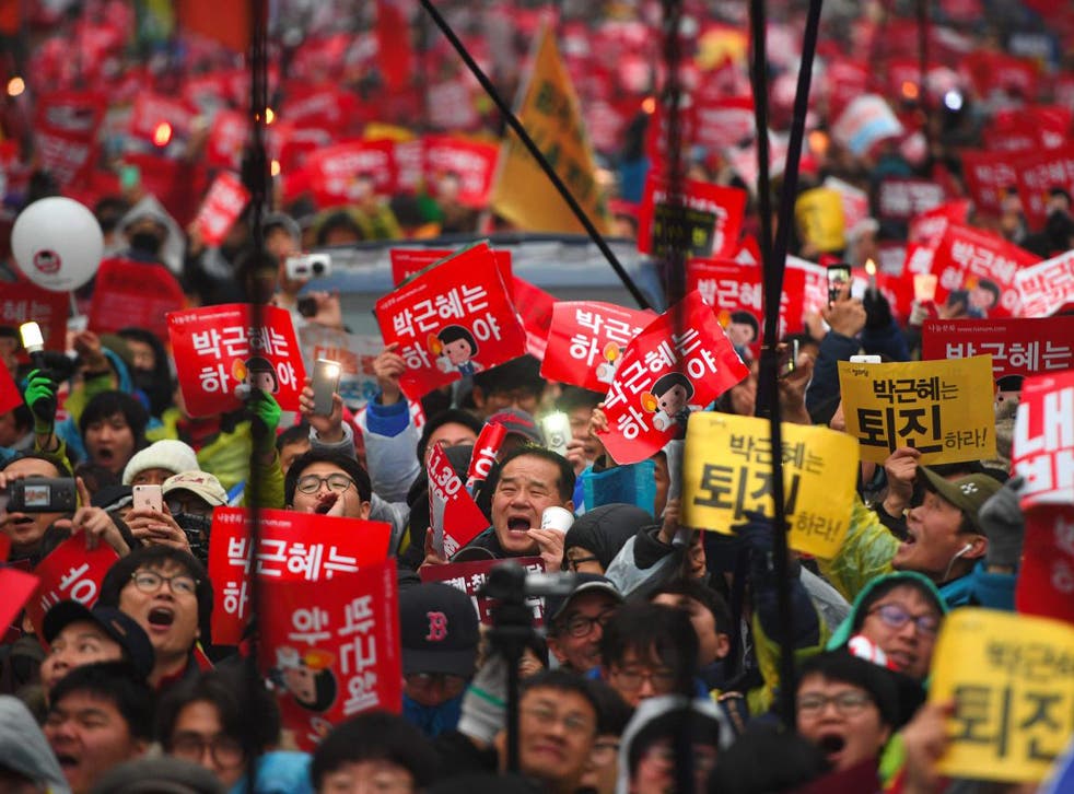 Protesters shout slogans as they march toward the presidential Blue House to press their demand for the resignation of South Korea's President Park Geun-Hye in central Seoul
