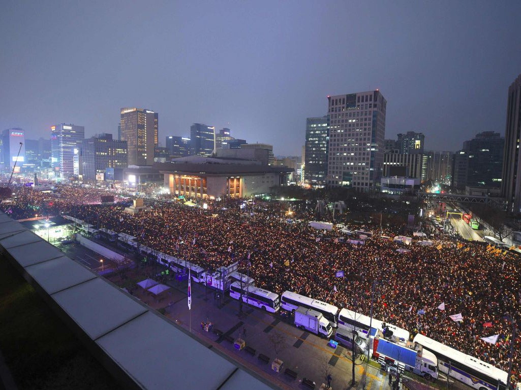 Protesters hold candles during an anti-government rally demanding the resignation of South Korea's President Park Geun-Hye