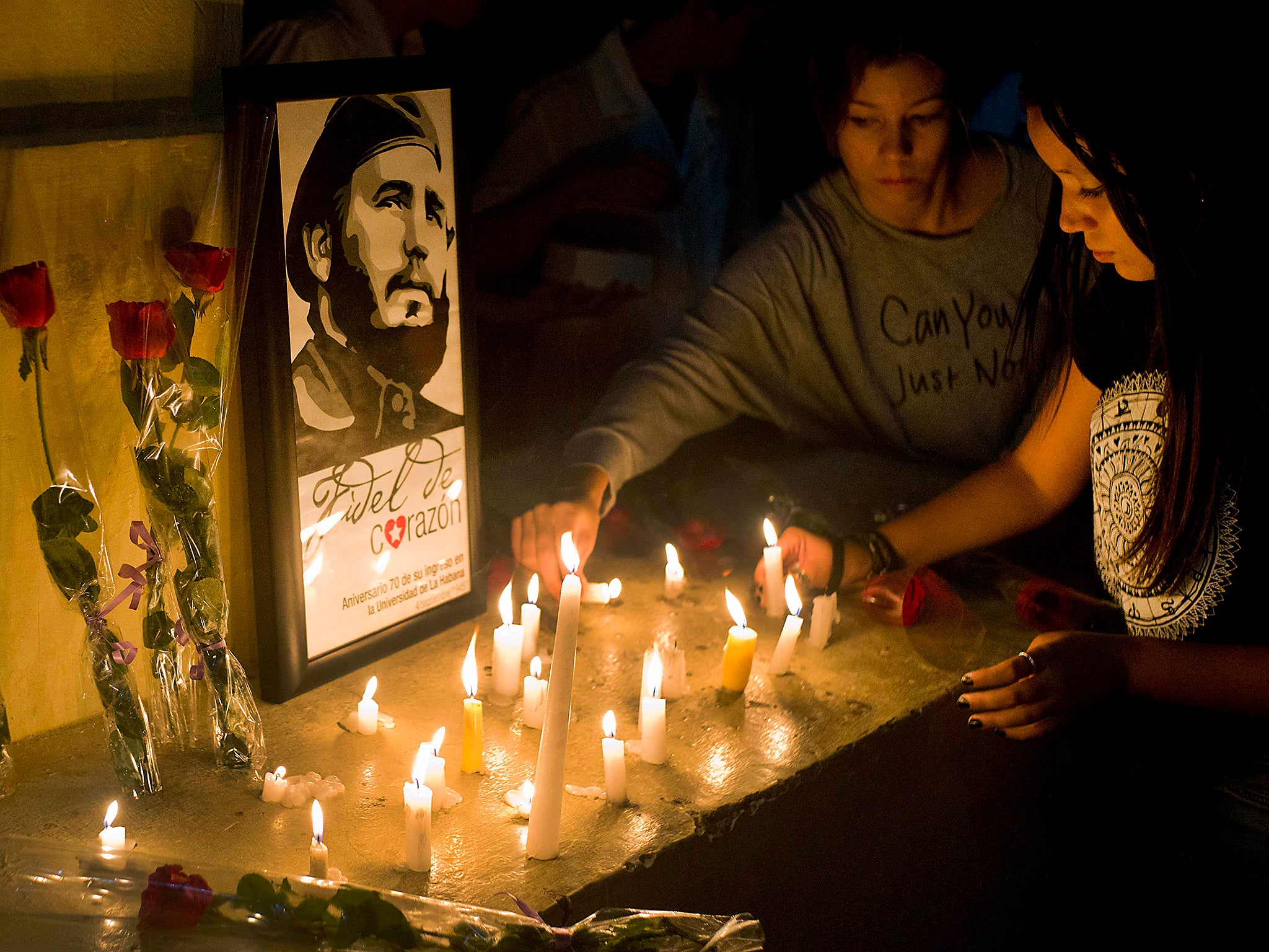 Students place candles around an image of the late Cuban leader Fidel Castro, at the university where Castro studied law as a young man, during a vigil in Havana, Cuba