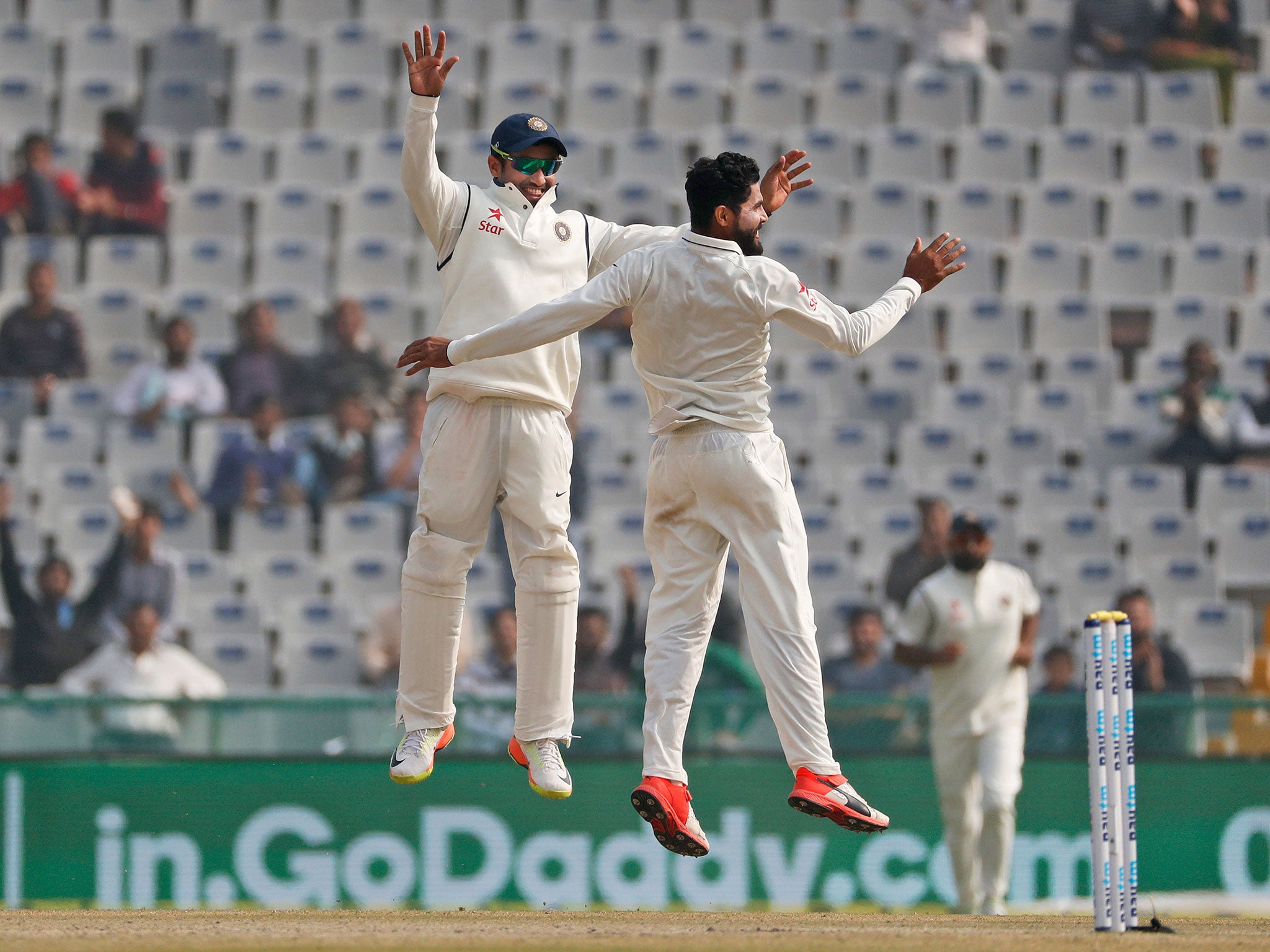 Ravindra Jadeja, right, and Karun Nair jump take to the air to celebrate Root's dismissal in Mohali