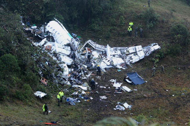 Police officers and rescue workers search for survivors around the wreckage of a chartered airplane that crashed in La Union, a mountainous area outside Medellin, Colombia