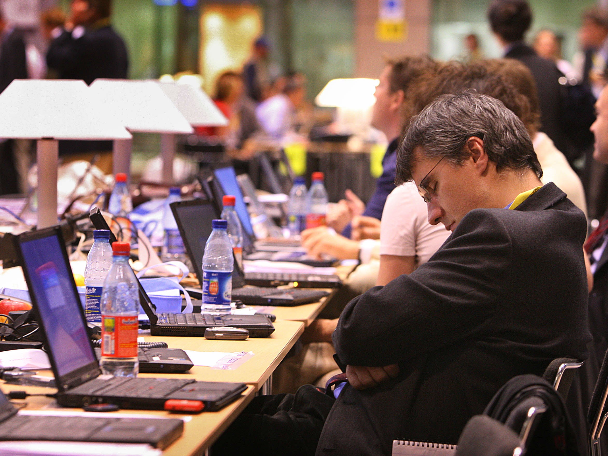 A journalist takes a nap during European Council negotiations in Brussels